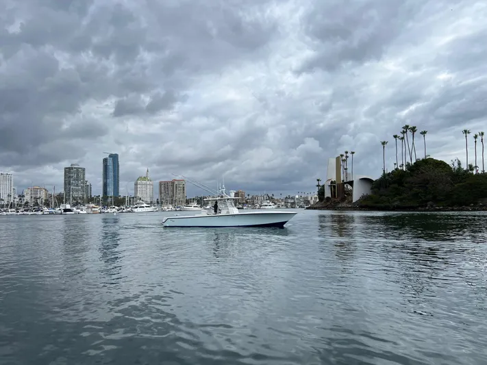 Part Time Hooker Yacht Photos Pics 2009 SeaVee IPS boat on calm water with city skyline and cloudy sky.