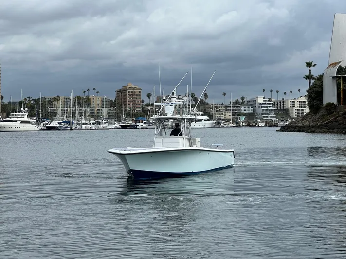 Part Time Hooker Yacht Photos Pics 2009 SeaVee IPS boat navigating a marina with cloudy skies and cityscape background.
