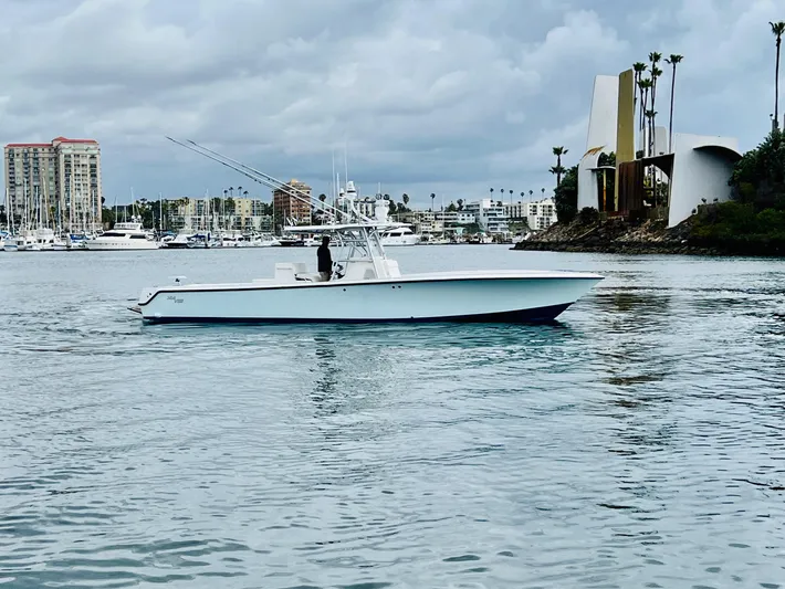 Part Time Hooker Yacht Photos Pics 2009 SeaVee IPS boat on calm water with cityscape and cloudy sky in the background.