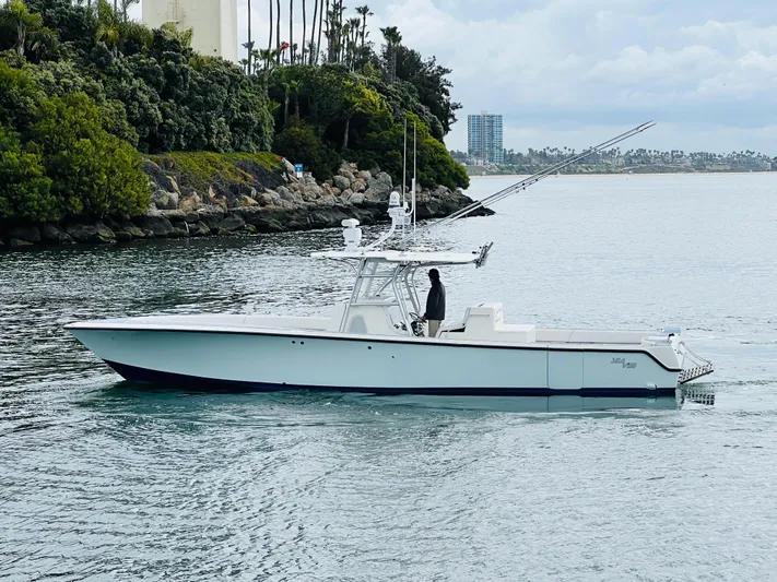 Part Time Hooker Yacht Photos Pics 2009 SeaVee IPS boat cruising on a calm waterway near lush greenery.