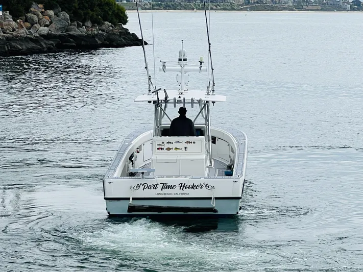 Part Time Hooker Yacht Photos Pics 2009 SeaVee IPS boat on water, rear view, with fishing rods and scenic background.