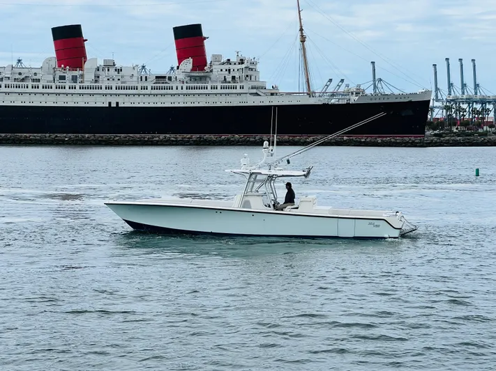 Part Time Hooker Yacht Photos Pics 2009 SeaVee IPS boat cruising near a large ship in a harbor.