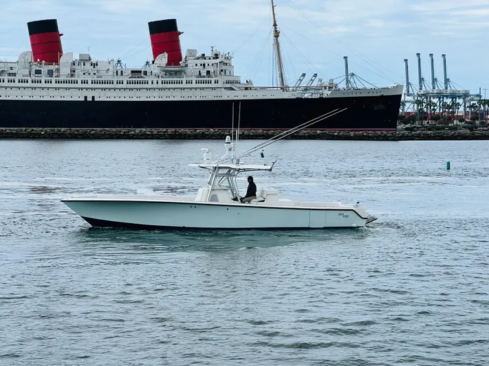 Part Time Hooker Yacht Photos Pics 2009 SeaVee IPS boat cruising near a large ship in a harbor setting.