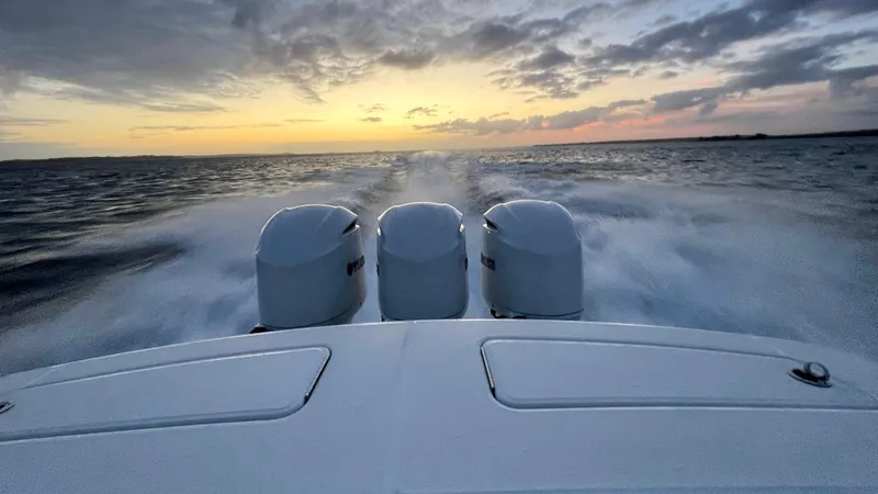 Three Ladies Yacht Photos Pics 2021 Regulator 34 boat with triple engines cruising at sunset on open water.