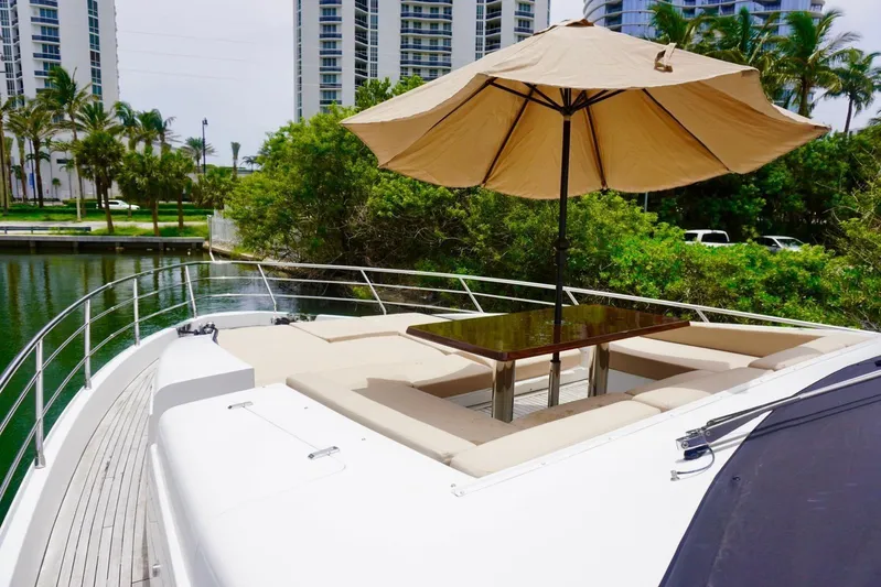  Yacht Photos Pics Luxurious 2015 Azimut 84 yacht deck with seating and umbrella, surrounded by lush greenery.