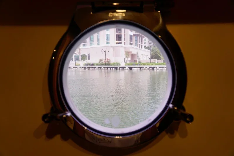  Yacht Photos Pics Porthole view from 2015 Azimut 84 yacht, overlooking waterfront buildings.