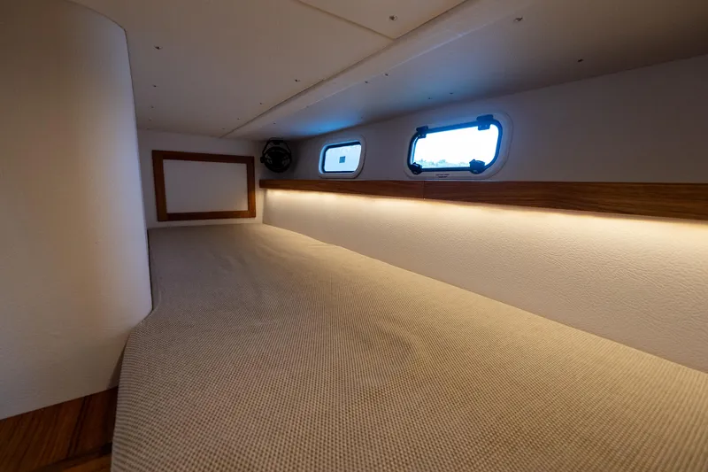 Stock 2 Yacht Photos Pics Interior cabin of 2025 Targa 32 GT boat with cozy bedding and porthole windows.