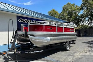 2026 Sun Tracker Bass Buggy 16 XL Select pontoon boat on trailer, outdoors.