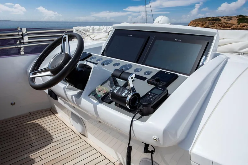  Yacht Photos Pics Control panel of a 2020 Princess F70 yacht with steering wheel and navigation screens.