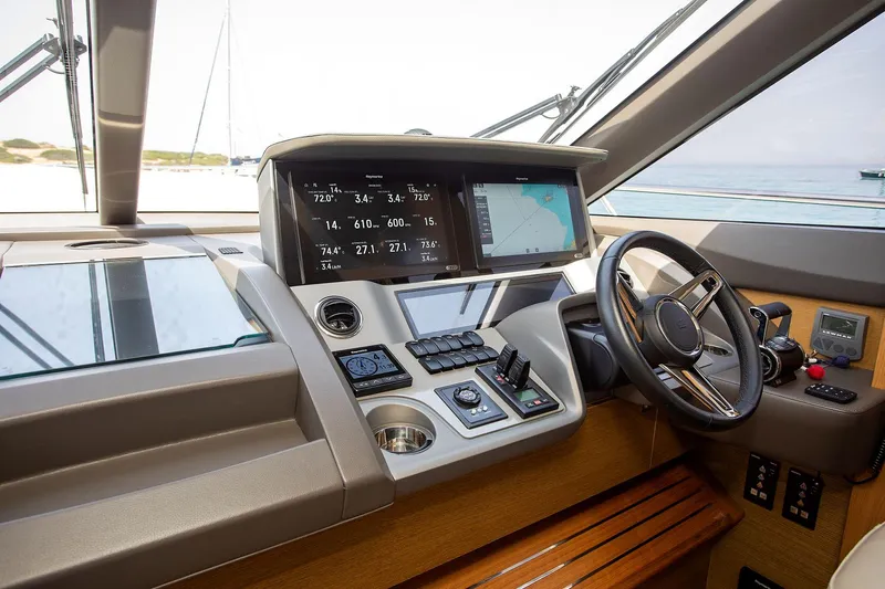  Yacht Photos Pics Control panel of a 2020 Princess F70 yacht with navigation screens and steering wheel.
