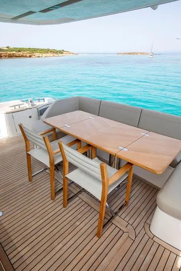  Yacht Photos Pics Luxury Princess F70 yacht deck with dining area, overlooking serene turquoise waters.