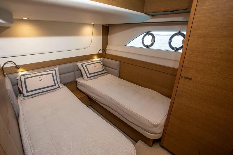  Yacht Photos Pics Luxurious twin cabin interior on 2020 Princess F70 yacht, featuring elegant bedding and porthole windows.