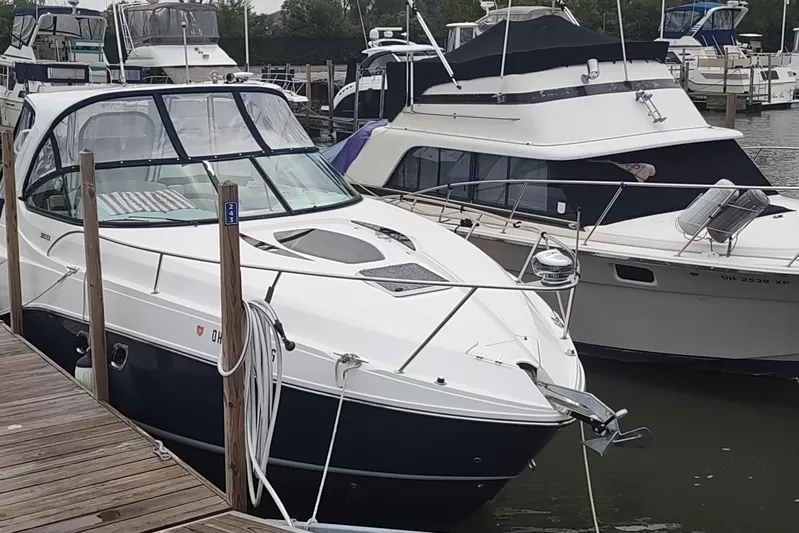  Yacht Photos Pics 2017 Rinker EX 320 boat docked at a marina, surrounded by other vessels.