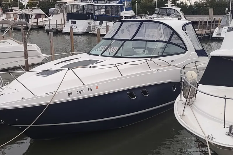  Yacht Photos Pics 2017 Rinker EX 320 boat docked in a marina, surrounded by other vessels.