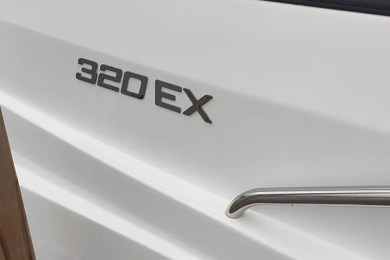  Yacht Photos Pics 2017 Rinker EX 320 boat emblem on white surface with metal handle.