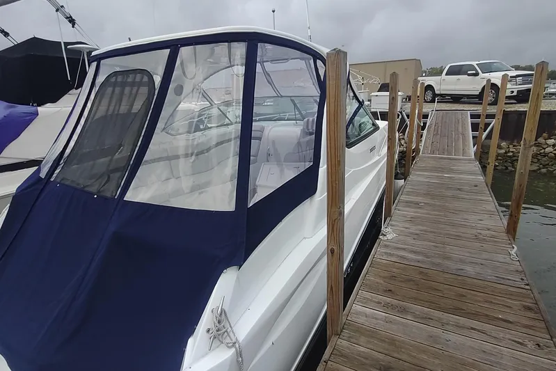  Yacht Photos Pics 2017 Rinker EX 320 boat docked beside wooden pier under cloudy sky.