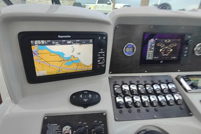 Yacht Photos Pics Control panel of 2017 Rinker EX 320 boat with navigation screens and switches.