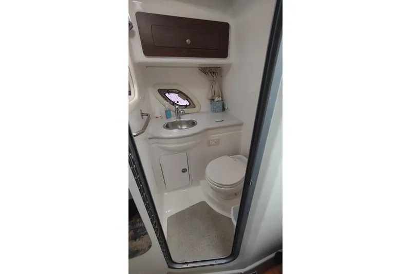  Yacht Photos Pics 2017 Rinker EX 320 boat bathroom with sink, toilet, and storage cabinet.