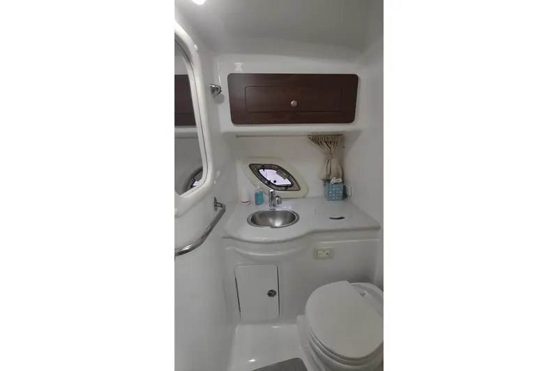  Yacht Photos Pics 2017 Rinker EX 320 boat bathroom with sink, toilet, and storage cabinet.