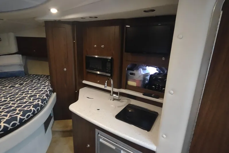  Yacht Photos Pics 2017 Rinker EX 320 cabin interior with kitchenette and bed.