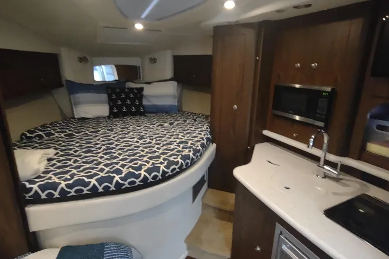  Yacht Photos Pics 2017 Rinker EX 320 cabin interior with bed, kitchenette, and microwave.