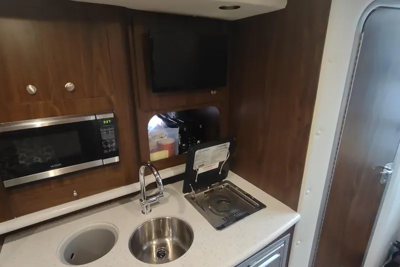  Yacht Photos Pics 2017 Rinker EX 320 yacht kitchenette with sink, microwave, and stove.