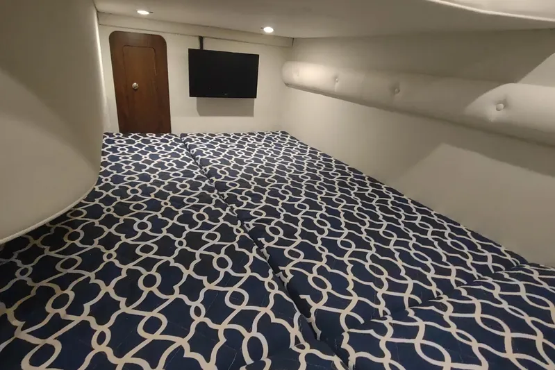  Yacht Photos Pics 2017 Rinker EX 320 cabin interior with patterned bedding and wall-mounted TV.