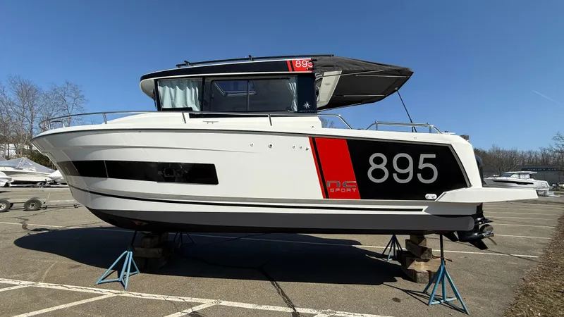 Scrimshaw III Yacht Photos Pics 2024 Jeanneau 895 Sport boat on stands in a parking lot.
