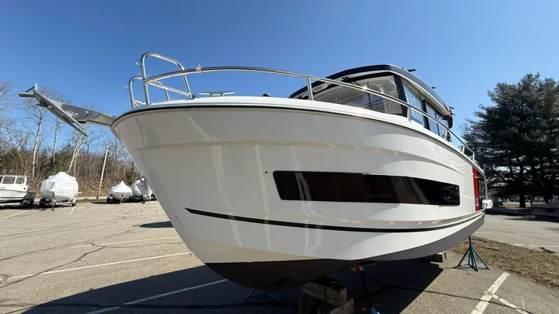 Scrimshaw III Yacht Photos Pics 2024 Jeanneau 895 Sport boat on display in a parking lot under clear blue sky.