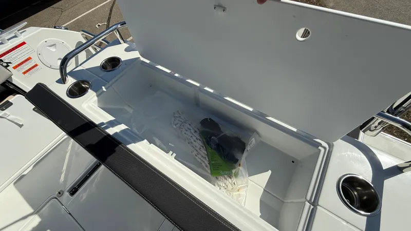 Scrimshaw III Yacht Photos Pics 2024 Jeanneau 895 Sport boat storage compartment with open lid and cup holders.