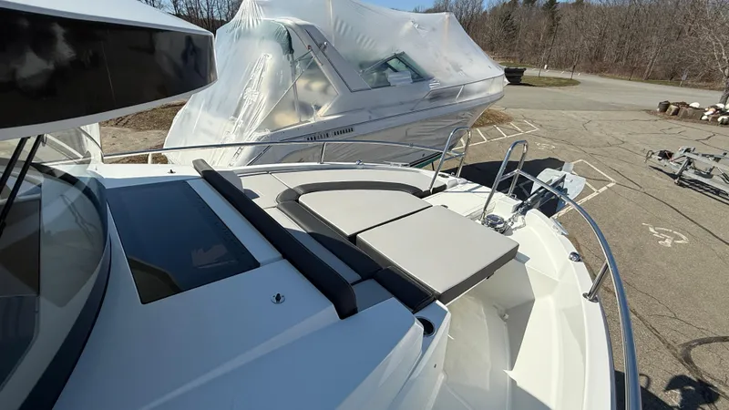 Scrimshaw III Yacht Photos Pics 2024 Jeanneau 895 Sport boat with sunbathing area, docked outdoors.