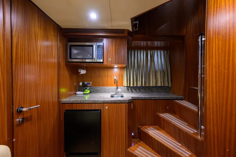 Claypen Yacht Photos Pics Compact kitchen area in 2013 Ocean Alexander Sky Lounge yacht with wood finish and modern amenities.