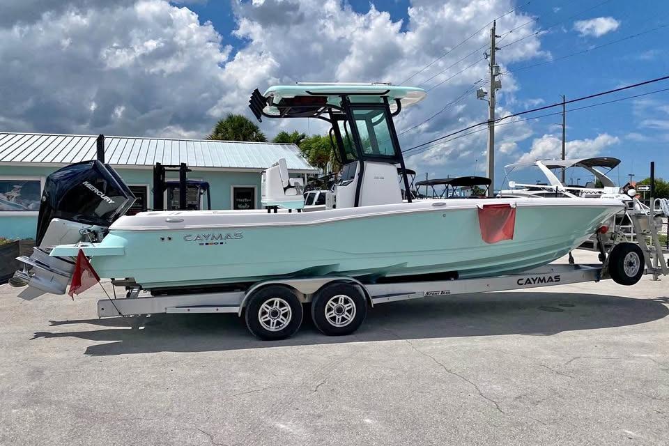 2023 Caymas 281 HB boat on trailer, parked outdoors under cloudy sky.