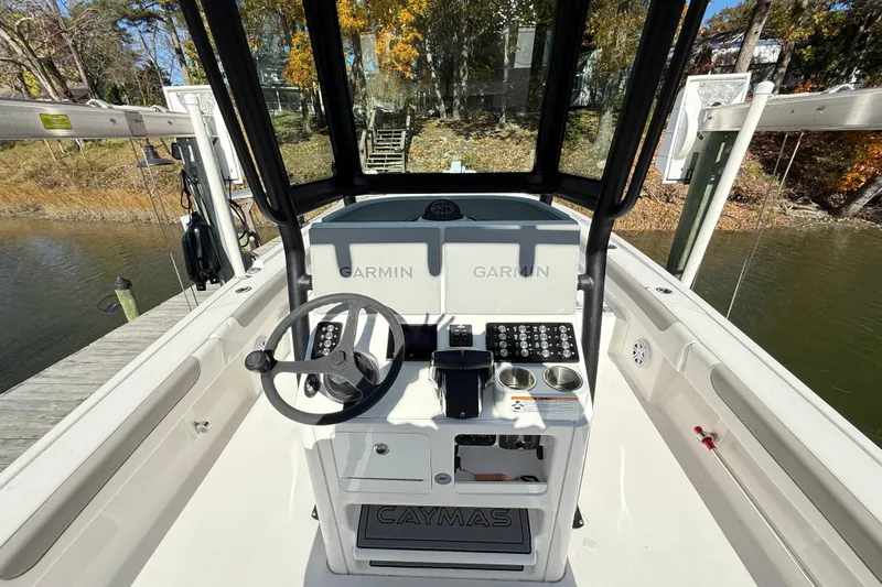  Yacht Photos Pics 2023 Caymas 281 HB boat helm with Garmin electronics, docked by a scenic waterway.