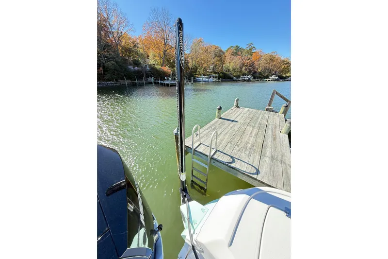  Yacht Photos Pics 2023 Caymas 281 HB boat docked by a wooden pier on a sunny day.