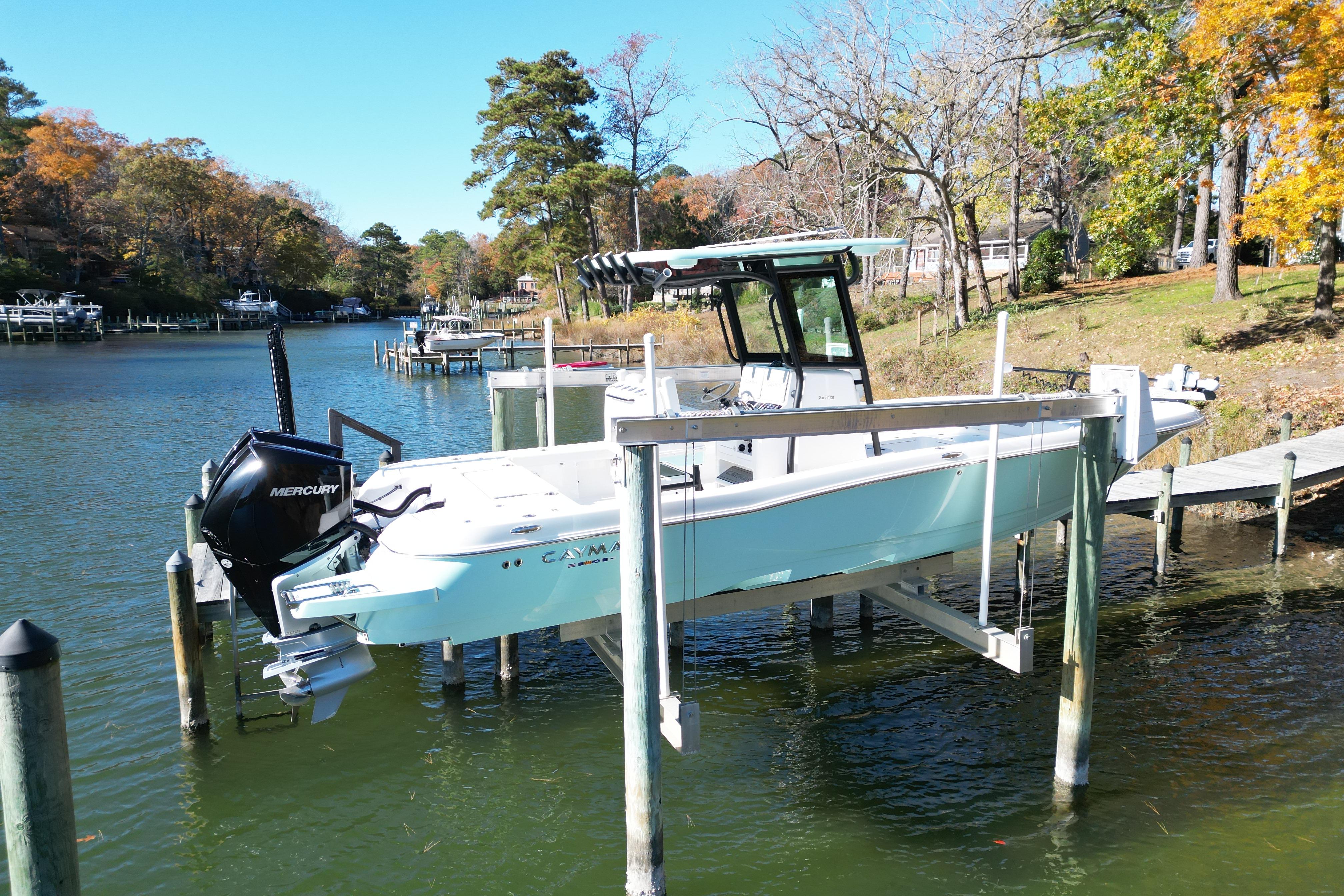2023 Caymas 281 HB boat docked on a serene lake with autumn foliage.