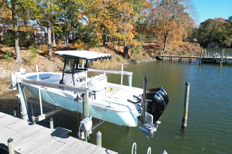  Yacht Photos Pics 2023 Caymas 281 HB boat on lift by autumn trees and calm water.