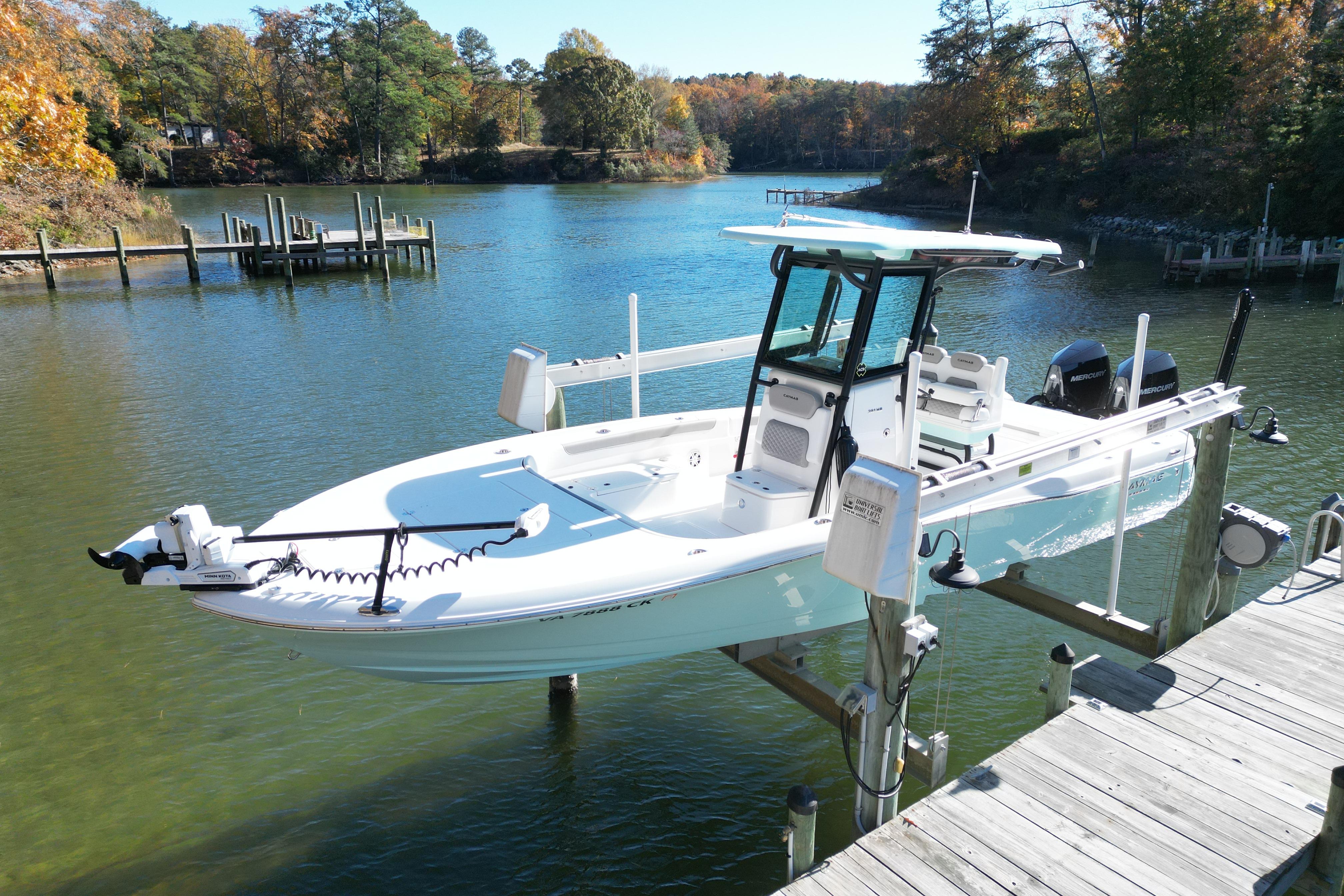 2023 Caymas 281 HB boat docked on a serene lake with autumn foliage.