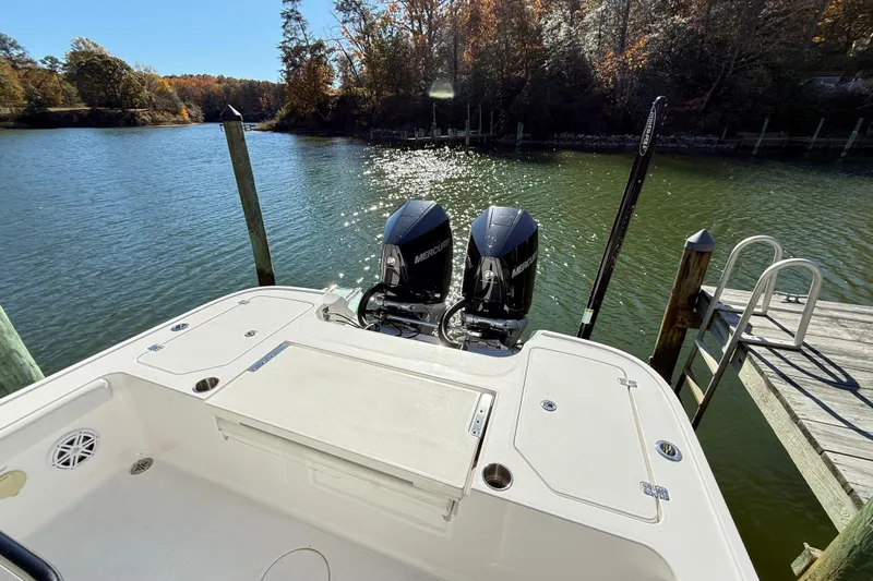  Yacht Photos Pics 2023 Caymas 281 HB boat with dual Mercury engines docked by a serene lake.