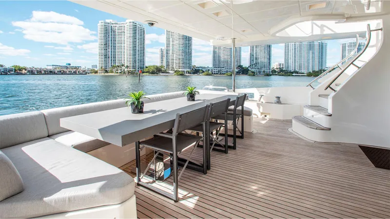Bt2 Yacht Photos Pics Luxurious Azimut 95 yacht deck with dining area, modern seating, and waterfront cityscape view.
