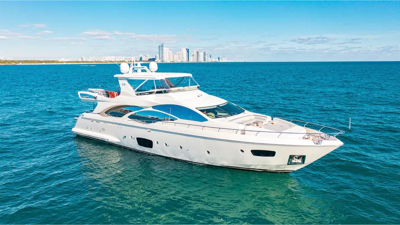 Bt2 Yacht Photos Pics Luxurious 2010 Azimut 95 yacht cruising on open water with city skyline backdrop.