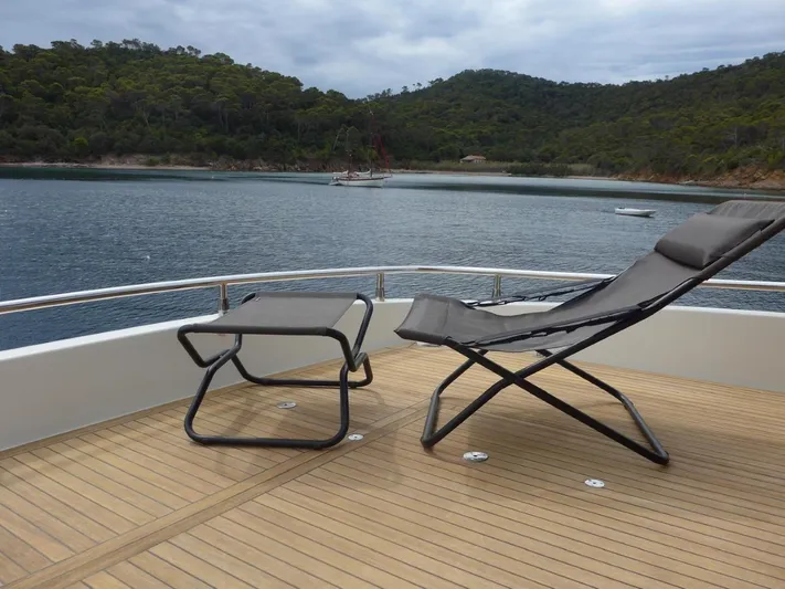 Getaway Yacht Photos Pics Deck of 2012 Gianetti Navetta 67 yacht with lounge chairs, overlooking serene waters and lush hills.
