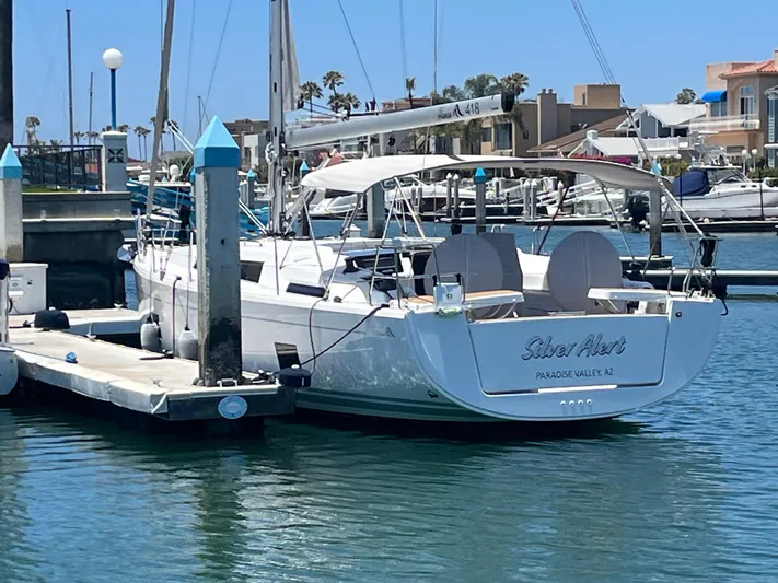 Silver Alert Yacht Photos Pics 2021 Hanse 418 sailboat docked in a marina under clear blue skies.