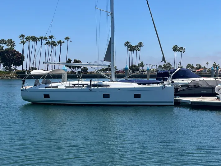 Silver Alert Yacht Photos Pics 2021 Hanse 418 sailboat docked in a marina with palm trees in the background.