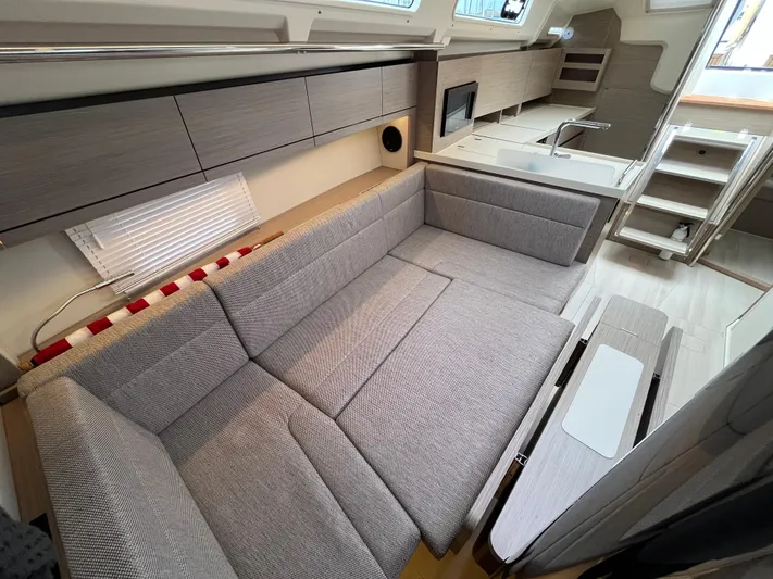 Silver Alert Yacht Photos Pics Modern interior of 2021 Hanse 418 yacht with sleek gray furnishings and compact kitchen.