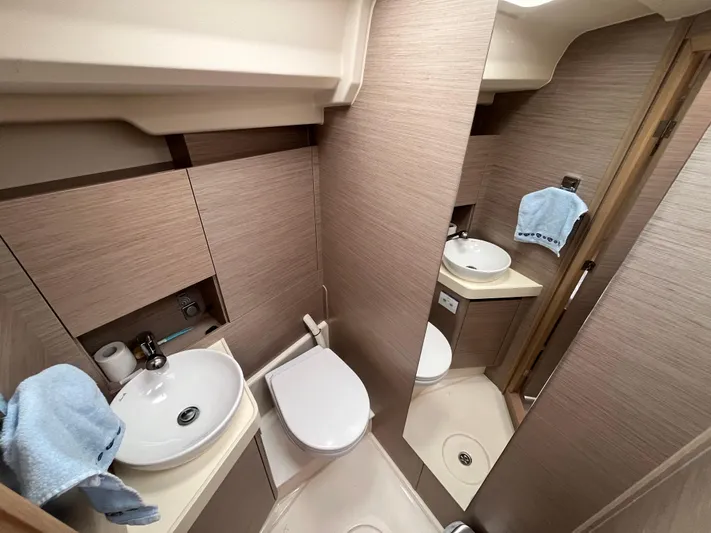 Silver Alert Yacht Photos Pics Modern bathroom in 2021 Hanse 418 yacht with sink, toilet, and mirror.