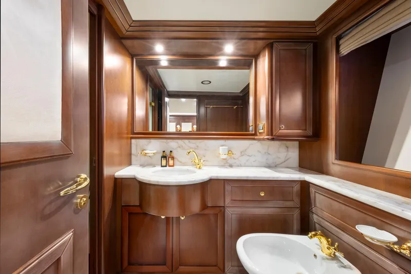 Hag Yacht Photos Pics Luxurious wooden bathroom interior on Custom Line Navetta 30 yacht, featuring marble countertops and gold fixtures.
