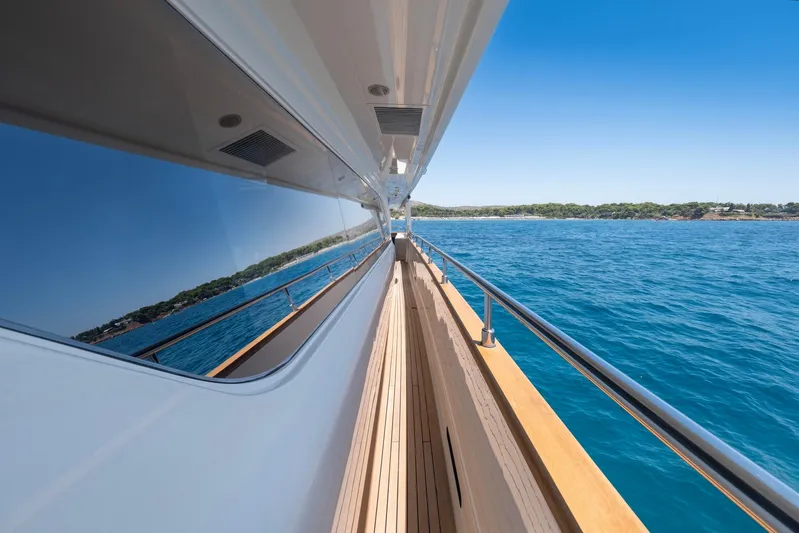 Hag Yacht Photos Pics Side view of Custom Line Navetta 30 yacht, 2007, reflecting ocean and coastline.