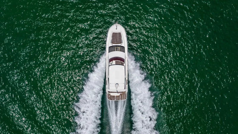 Motivated Seller Yacht Photos Pics Aerial view of 2019 Prestige 520 yacht cruising on open water.