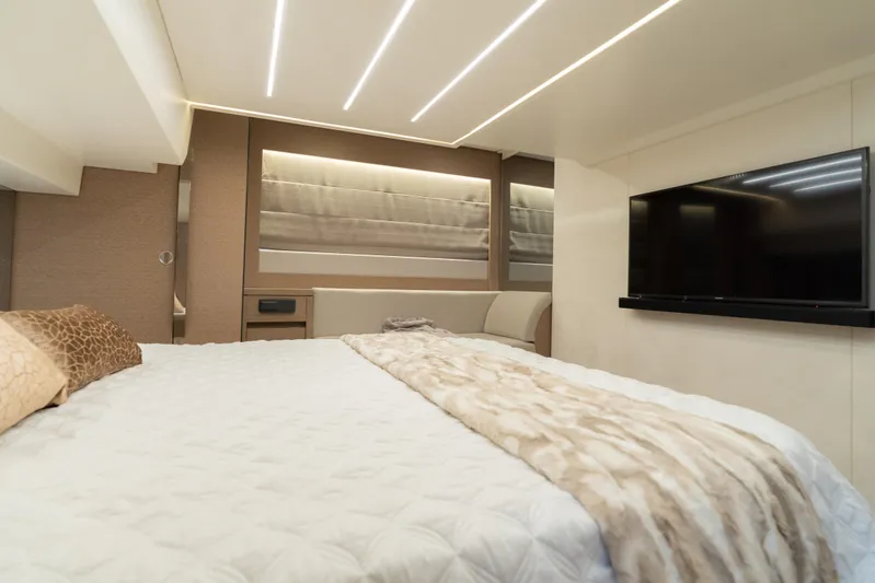 Motivated Seller Yacht Photos Pics Luxurious bedroom interior of 2019 Prestige 520 yacht with modern decor and flat-screen TV.